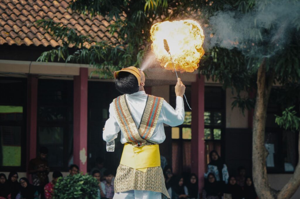 A captivating fire-breathing performance by a young performer in traditional attire in West Java, Indonesia.