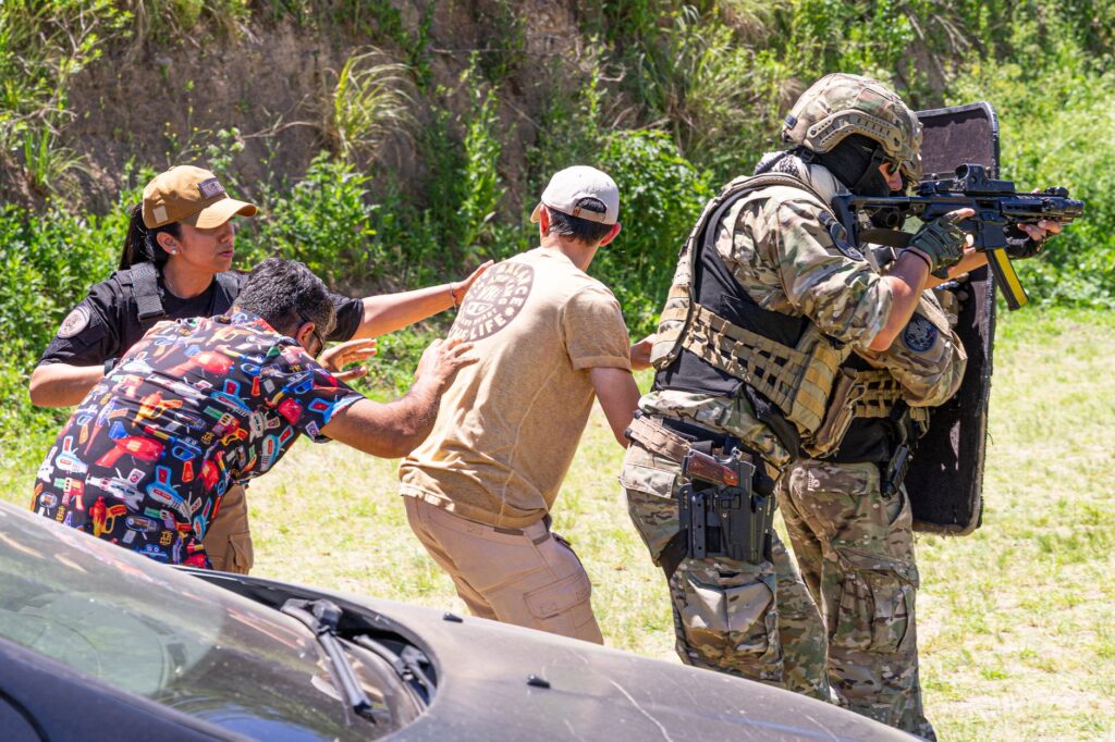 Military personnel in outdoor exercise, showcasing tactical and defensive skills with civilians.