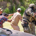 Military personnel in outdoor exercise, showcasing tactical and defensive skills with civilians.