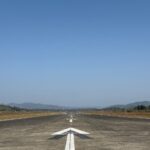 Clear day view of an empty airstrip with mountains in the background, set in Meghalaya, India.