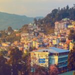Stunning view of Gangtok, Sikkim at sunset showcasing vibrant urban landscape and scenic hills.