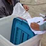 Election authorities managing ballot box during Nepal election.
