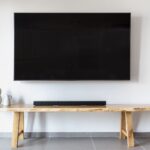 Stylish minimalist living room featuring a wall-mounted flat screen TV and wooden console.