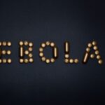 Medicinal pills arranged to spell 'EBOLA', symbolizing treatment and healthcare theme.
