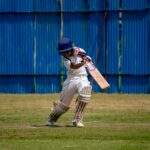 Young cricketer in action on a sunny day at a field in Gahunje, MH, India.