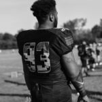 Black and white image of a football player wearing jersey number 93 during a game day.