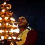 A man performing a traditional Indian candlelight ritual at night in Varanasi, India.