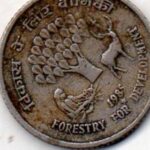 Detailed close-up of a vintage Indian coin commemorating forestry development, dated 1985.