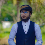 Elegant portrait of a bearded man wearing a turban and vest outdoors in Noakhali, Bangladesh.