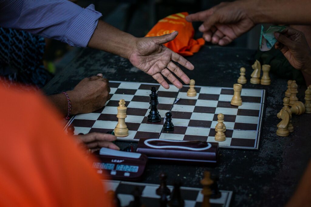 Street chess match in Bali, Indonesia with multiple players involved in a strategic conversation.