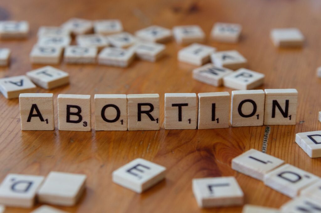 Scrabble tiles spelling 'abortion', highlighting the debate on reproductive rights.