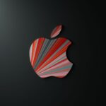Colorful striped pattern on an apple-shaped design on a dark background, artistic and modern.
