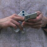 Detail of hands holding two smartphones, showcasing modern technology usage.