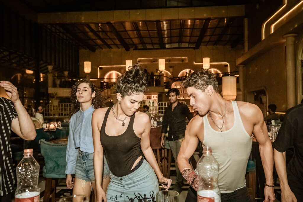 Group of young adults enjoying a lively night out at a trendy Indian bar with friends.