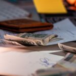 Zloty banknotes and financial paperwork scattered on a desk, representing budgeting and finance.