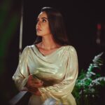 Woman in a shimmery gold dress under evening lights in Baghdad, Iraq.