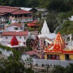 A vibrant aerial shot of the famous Kainchi Dham Temple complex surrounded by lush greenery in Uttarakhand.