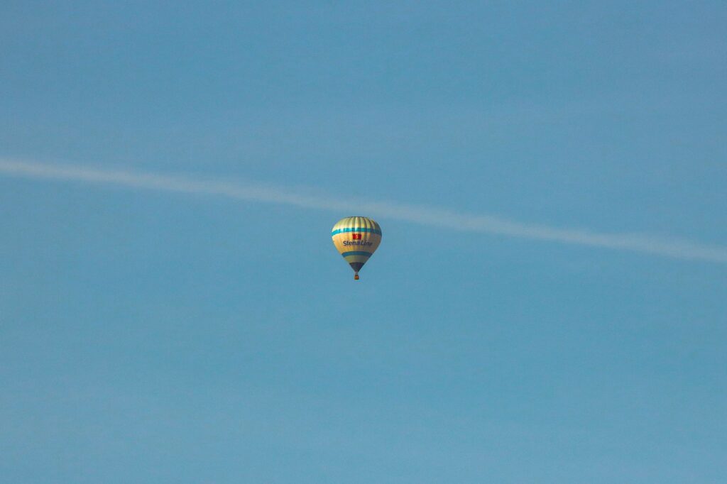 A solitary hot air balloon floats against a clear blue sky in Gothenburg, Sweden.