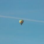 A solitary hot air balloon floats against a clear blue sky in Gothenburg, Sweden.