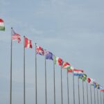 A row of international flags on flagpoles symbolizing global unity and diplomacy.