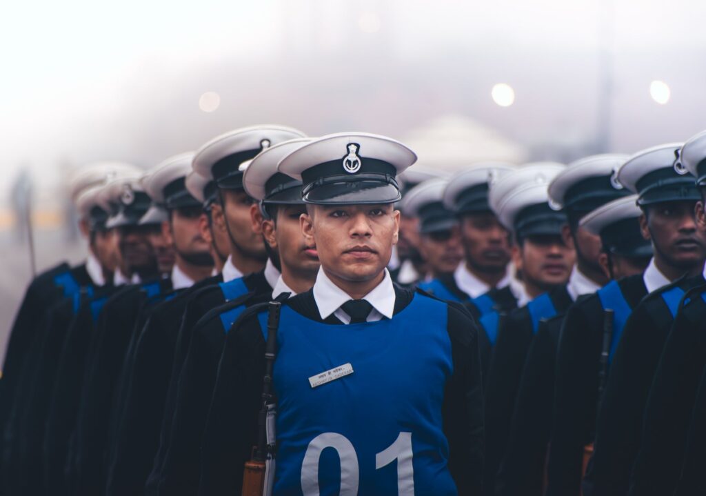 A line of uniformed military personnel marching in formation during a parade.