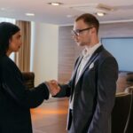 Two professionals shaking hands in a modern conference room, symbolizing successful business agreement.