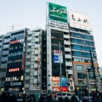Dynamic view of a bustling Tokyo street with colorful billboards and busy pedestrian traffic.
