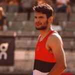 Portrait of a determined male athlete in a sports setting, capturing focused expression and athletic attire.