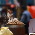 Freshly roasted peanuts steaming atop a street stall in Bengaluru, India.