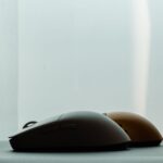 Silhouette of two wireless computer mice against a soft background, highlighting modern technology design.