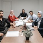 A diverse group of professionals engaging in a business meeting in a modern office setting.