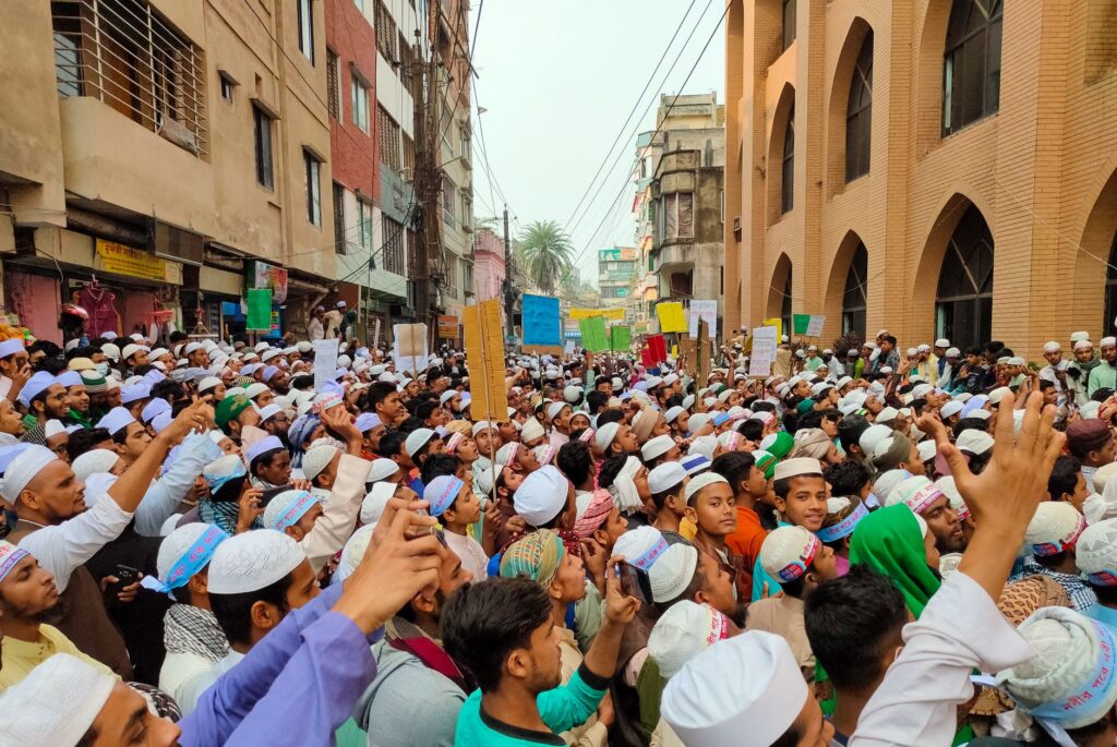 Large group of people protesting on a street with placards, showcasing civic activism.