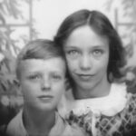 Vintage black and white portrait of siblings in a close pose.