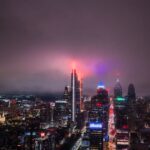 Aerial view of the Philadelphia skyline at night with vibrant city lights illuminating the skyscrapers.