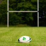 Rugby ball on a grassy field with goal posts in the background, Galway, Ireland.