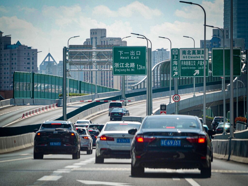 Cars on an elevated highway navigating through Shanghai's urban landscape.