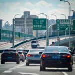 Cars on an elevated highway navigating through Shanghai's urban landscape.