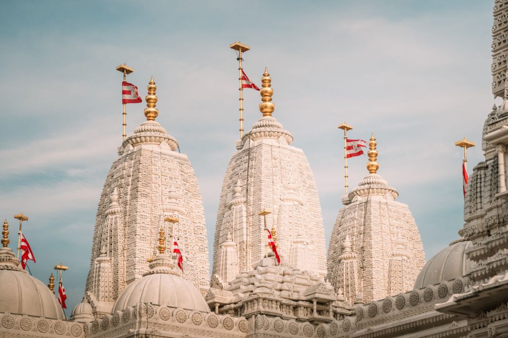 Beautiful white stone spires of BAPS Shri Swaminarayan temple against a clear sky.
