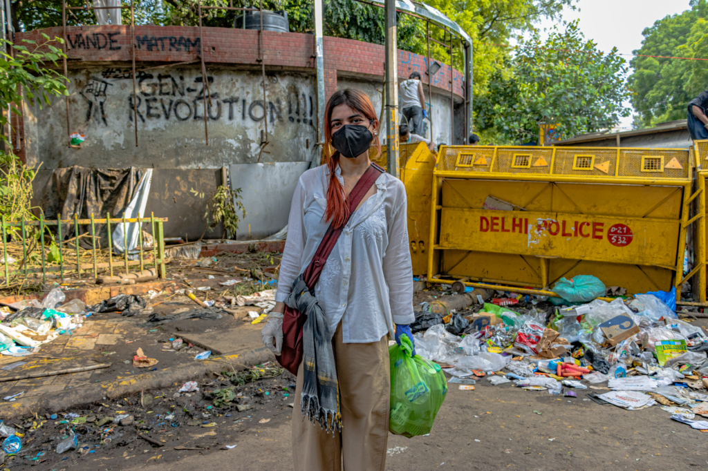 A protester stands in front of a barricade and graffiti at a New Delhi protest site.