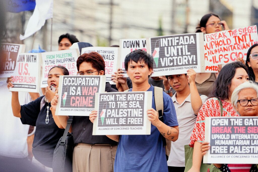 A group of demonstrators holding signs in support of Palestine at a protest rally.