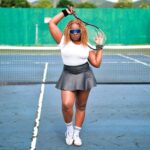 Female tennis player poses confidently with a racket on an outdoor court in Saint Kitts.