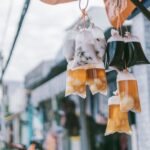 Plastic bags of drinks hanging in an urban street setting showcasing local street food culture.