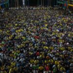 A vibrant gathering of diverse people at an indoor event in Dhaka, Bangladesh.
