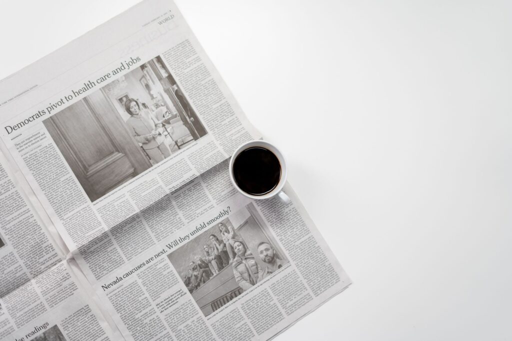 A fresh cup of coffee resting on a newspaper, perfect morning routine setup.