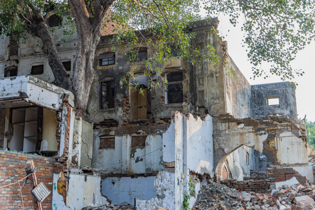 Ruins of an abandoned heritage building overgrown by trees in Delhi, India.