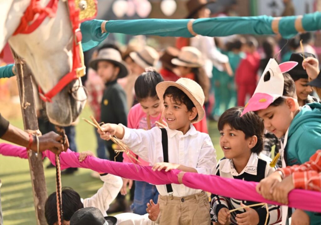 Kids interact with a horse during a lively play school event in India.