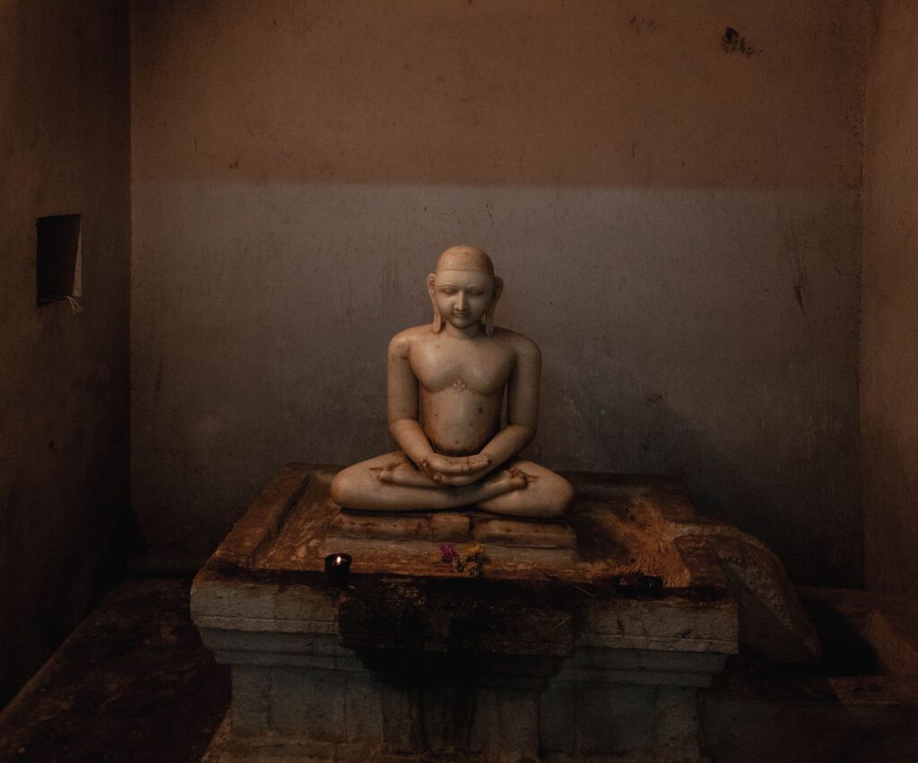 A tranquil marble statue in a dimly lit temple in Kanchipuram, India, exuding calmness.