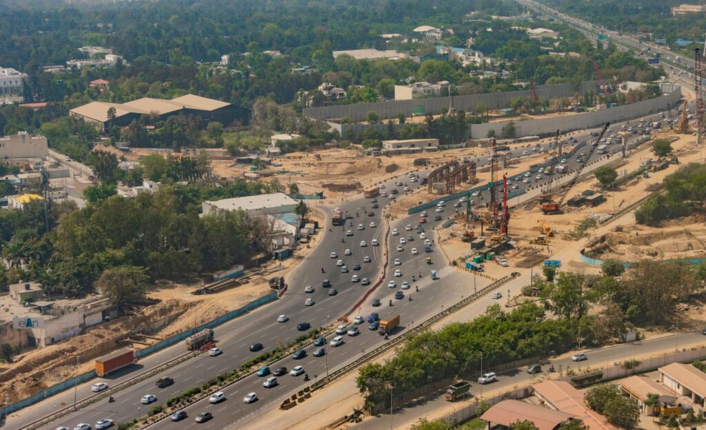 Aerial shot of busy expressway in New Delhi, showcasing traffic and city development.