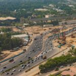Aerial shot of busy expressway in New Delhi, showcasing traffic and city development.