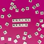 Alphabet tiles forming 'Social Media' on a vibrant pink background, perfect for digital marketing themes.
